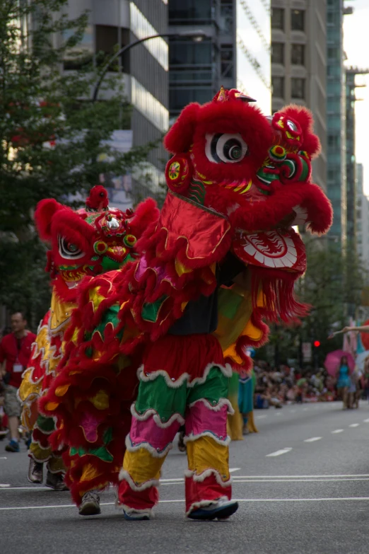 a group of people walking down a street in a parade, inspired by Lu Guang, flickr, dragon - inspired suit, vancouver, square, medium closeup shot