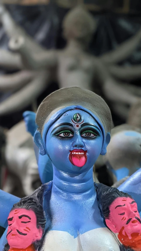 a close up of a figurine of a woman, by Sunil Das, devil horns, happy with his mouth open, blueish, ap