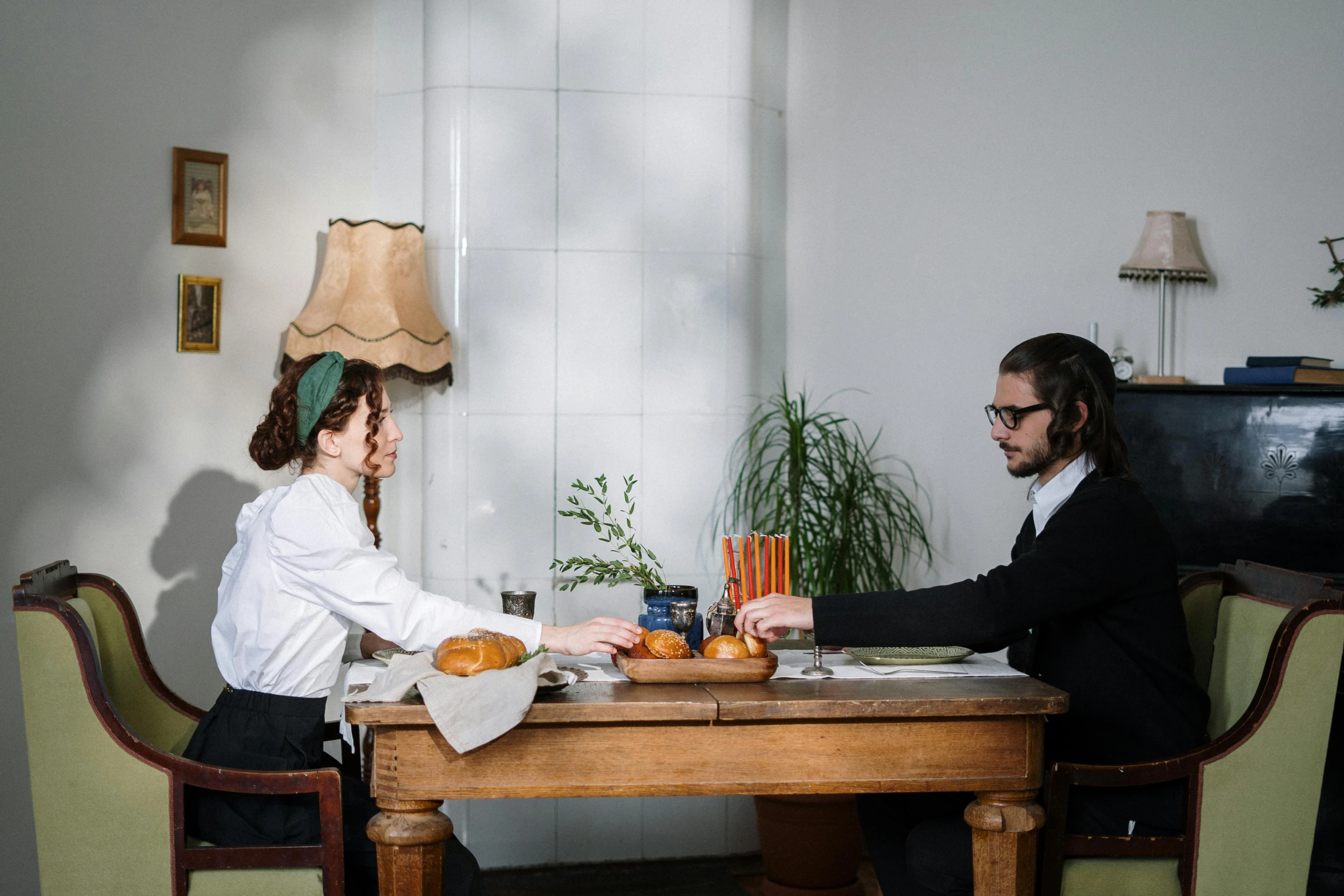 a man and a woman sitting at a table, by Julia Pishtar, pexels contest winner, sukkot, ignant, white table, chef table