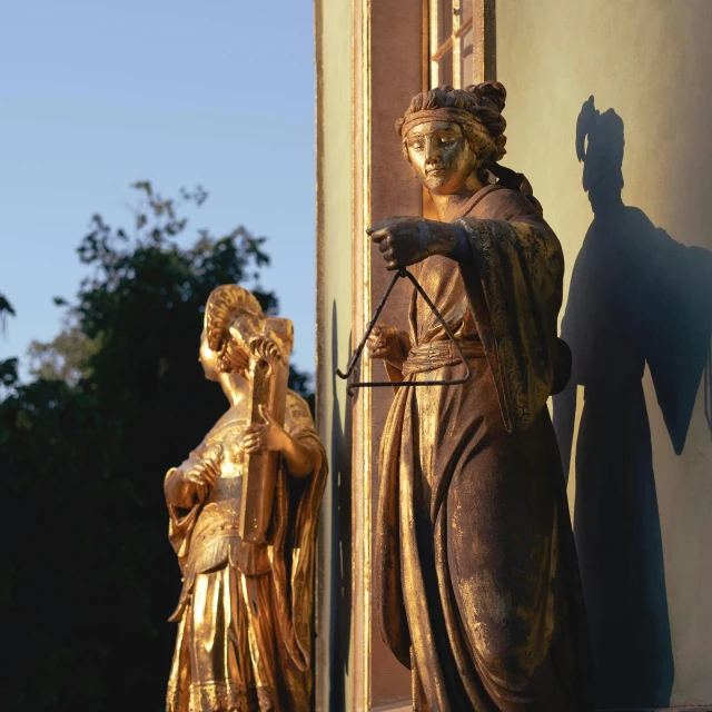 a statue of a woman standing next to a statue of a man, a statue, inspired by Károly Markó the Elder, mannerism, shining golden hour, wooden decoration, golden windows, holding a scepter