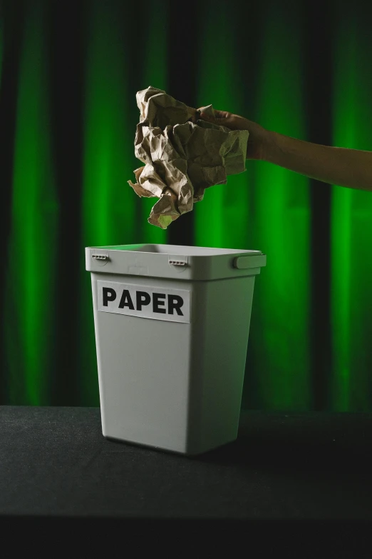 a person throwing a piece of paper into a trash can, an album cover, by Julia Pishtar, pexels contest winner, conceptual art, one green, porcelain organic tissue, stop motion, scientific paper