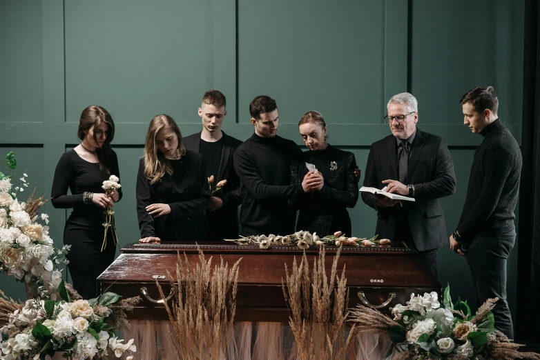 a group of people standing around a casket, profile image