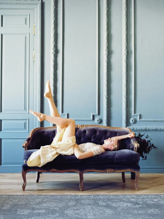 a woman laying on a couch in a room, inspired by Balthus, trending on unsplash, rococo, dancing gracefully, architectural digest, cream and blue color scheme, marie - gabrielle capet style