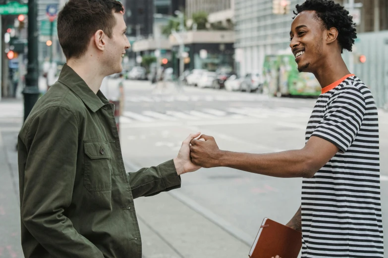 two men shaking hands on a city street, pexels contest winner, lgbtq, mix of ethnicities and genders, smiling couple, promo image