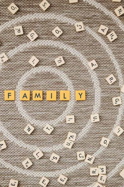 the word family spelled in scrabbles on a canvas background, pixabay, folk art, circle, genetic, gold, square