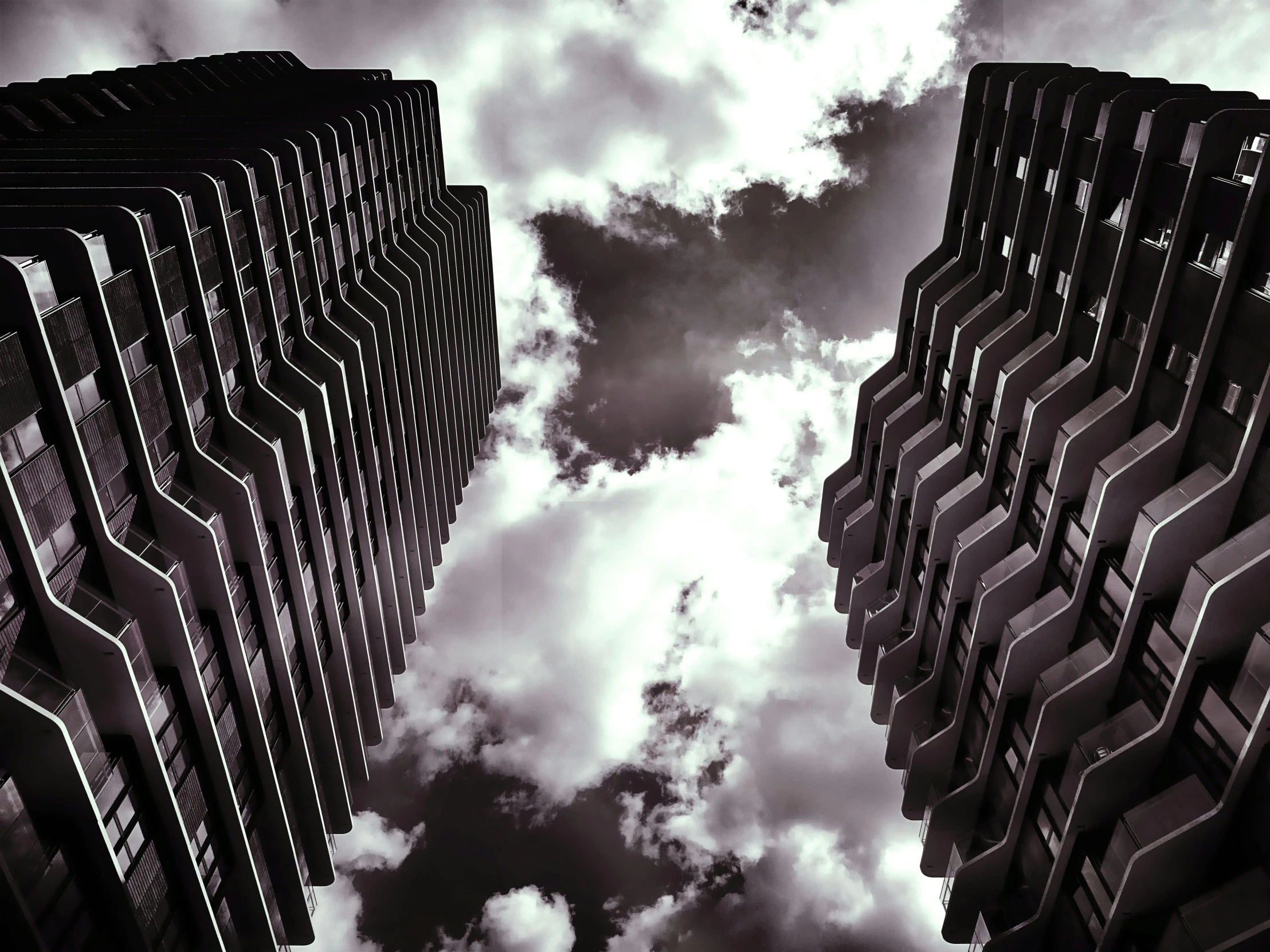 a black and white photo of tall buildings, by Adam Rex, pexels contest winner, brutalism, two organic looking towers, surreal clouds, photo high definition, 1 4 9 3