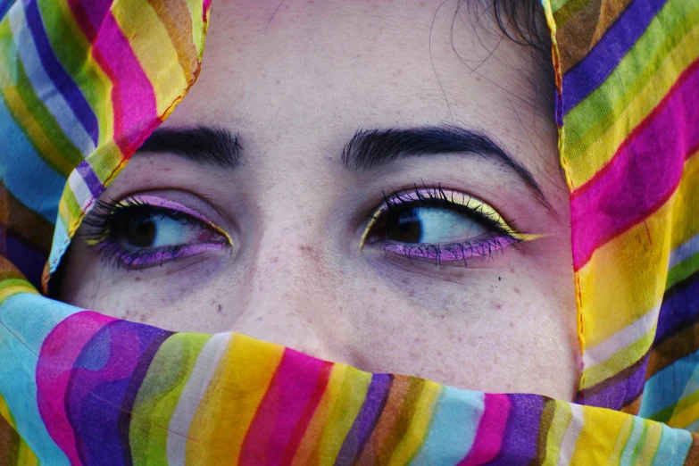 a woman with a colorful scarf covering her face, an album cover, trending on pexels, wide golden eyes, colorful]”, middle eastern, color 3 5 mm