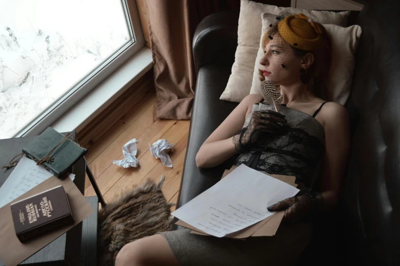 a woman sitting in a chair next to a window, inspired by Balthus, pexels contest winner, costumes from peaky blinders, with notes, on a couch, high angle shot