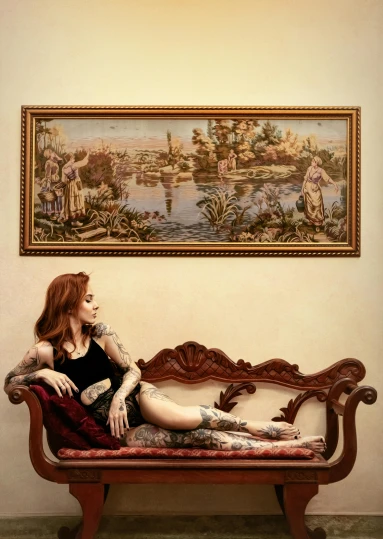 a woman sitting on a couch in front of a painting, an album cover, inspired by Pieter Aertsen, tattoo, lake view, detailed pixel artwork, hyperrealism photo