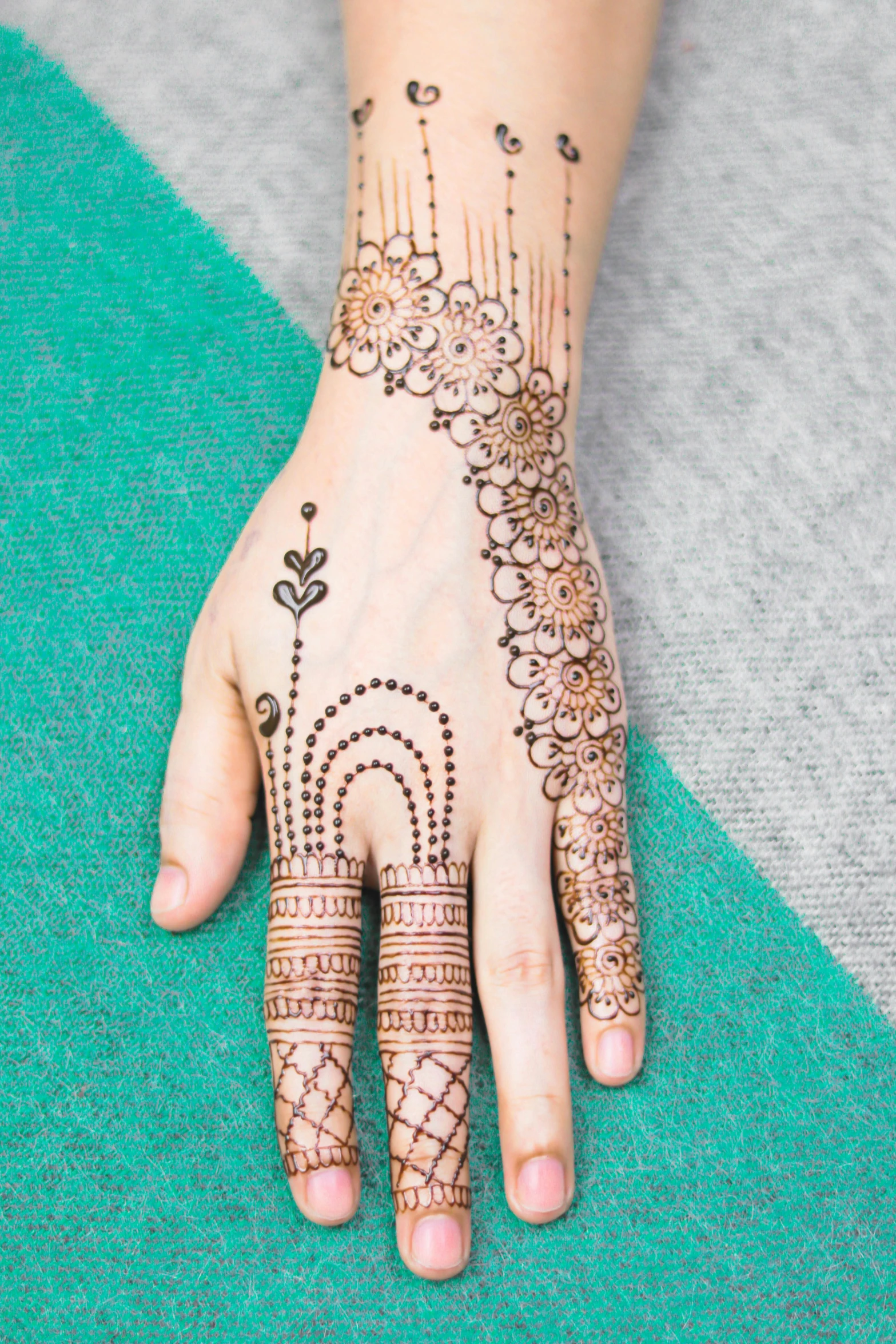 a woman's hand with henna tattoos on it, square, tall, edited, patterned