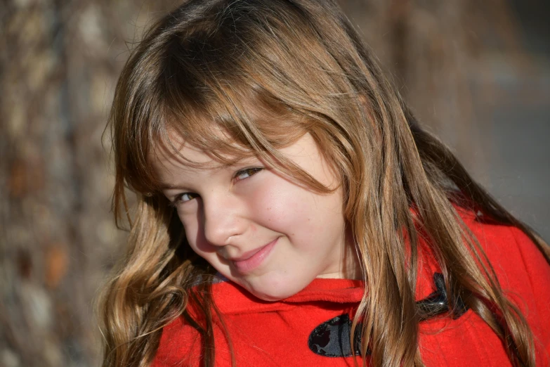 a close up of a child wearing a red coat, by Gwen Barnard, pixabay contest winner, portrait of beautiful girl, tourist photo, brown, family photo