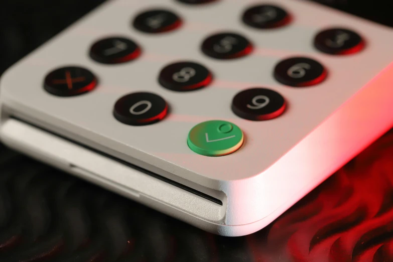 a close up of a remote control on a table, an album cover, by John Button, unsplash, red and green lighting, ergodox, avatar image, clover