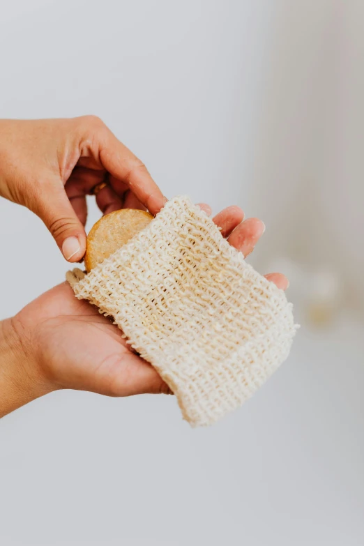 a person holding a scrub cloth in their hand, by Robbie Trevino, square, natural soft light, manuka, bath