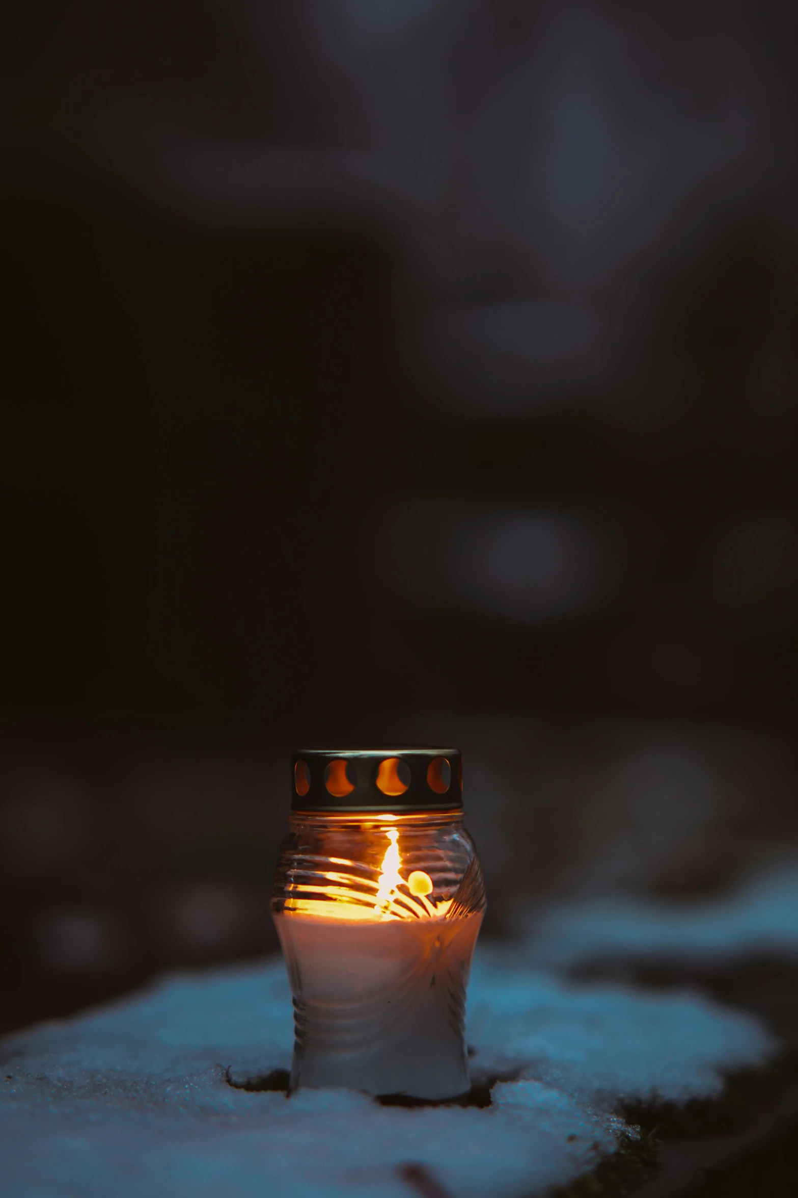 a lit candle sitting on top of snow covered ground, glowing jar, rip, profile picture, dark. no text