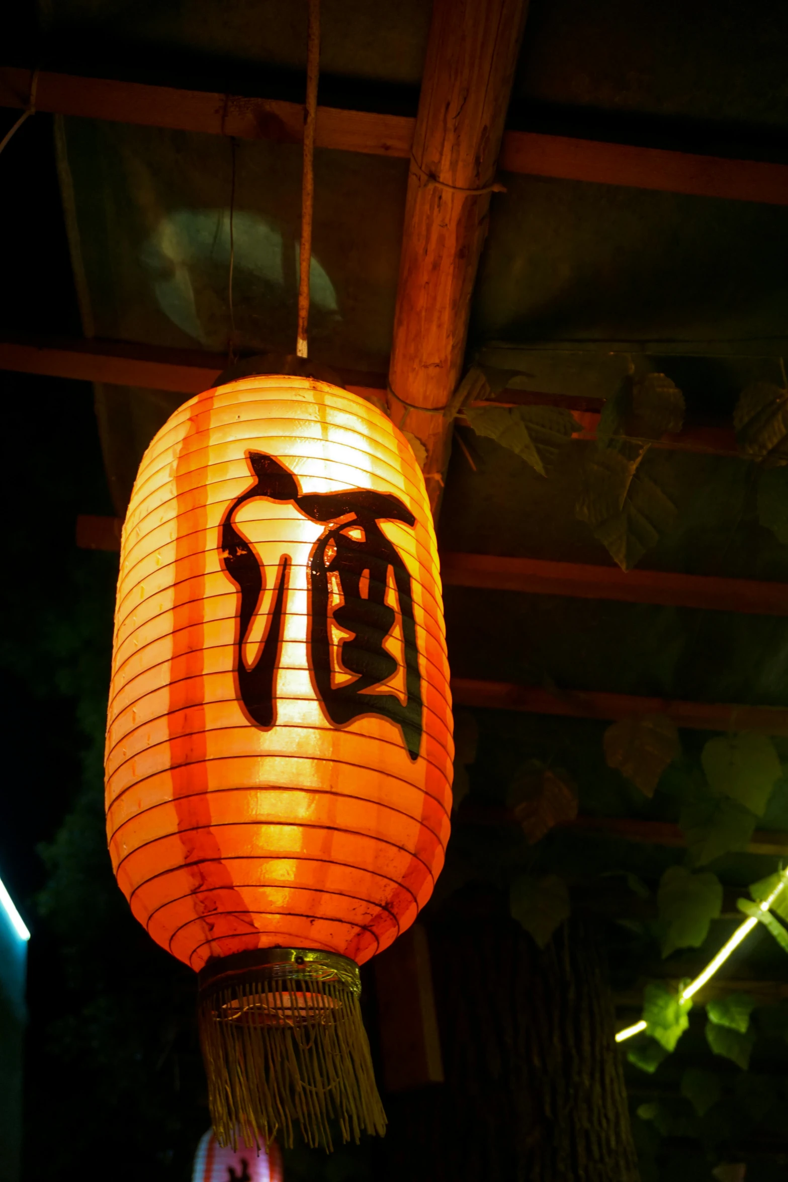 a lantern hanging from the ceiling of a restaurant, sōsaku hanga, with orange street lights, guan yu, nighttime!