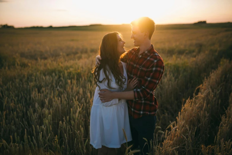 a couple standing in a field at sunset, pexels contest winner, attractive, white, smiling, owen klatte