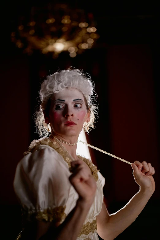 a woman in a white dress holding a wand, inspired by Pietro Longhi, rococo, videotape still from 1985, smirking, drag, [ theatrical ]