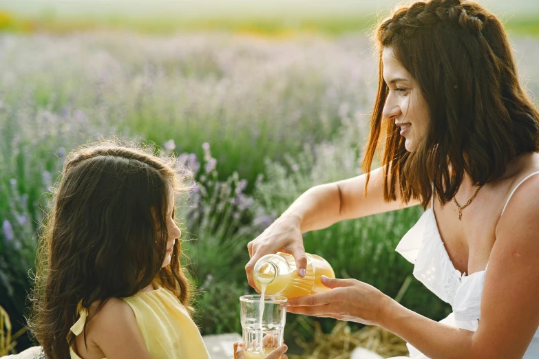 a woman pouring orange juice to a little girl, pexels contest winner, lavender, summer setting, avatar image, manuka