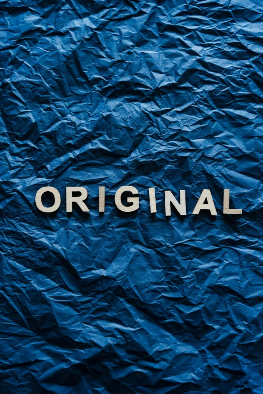 a blue crumpled paper with the word original written on it, an album cover, by artist, trending on unsplash, international typographic style, avatar image, navy, official product image, #trending