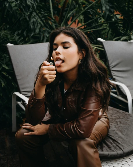 a woman sitting on a chair brushing her teeth, an album cover, inspired by Elsa Bleda, trending on pexels, madison beer girl portrait, cigars, profile image, botanicals