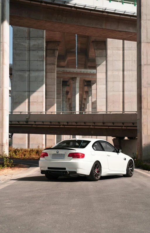 a white car is parked under a bridge, pexels contest winner, bmw, low quality photo, profile, multi chromatic