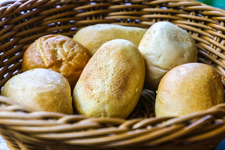 a basket filled with rolls of bread sitting on top of a table, unsplash, mingei, fan favorite, bao pham, chilean, soft skin