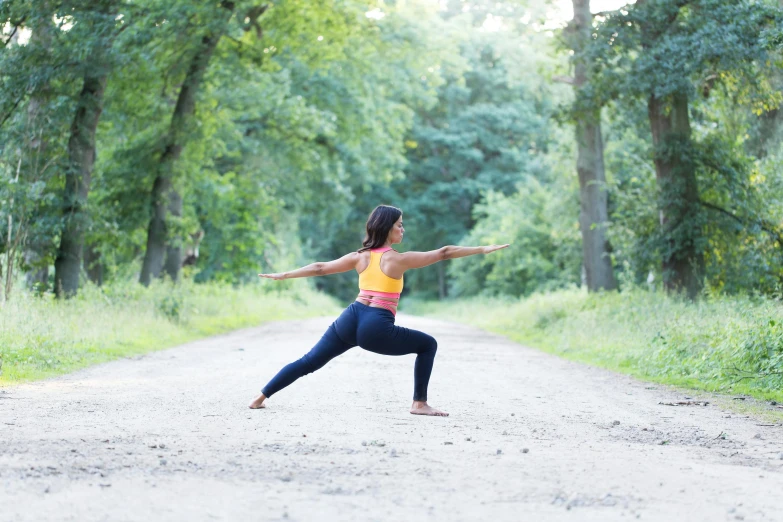 a woman doing a yoga pose on a dirt road, pexels contest winner, arabesque, avatar image, looking partly to the left, outdoor photo, shapely derriere