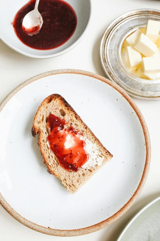 a close up of a plate of food on a table, inspired by Richmond Barthé, unsplash, brown bread with sliced salo, marmalade, gradient white to red, butter