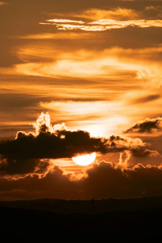 the sun is setting behind the clouds in the sky, by Linda Sutton, unsplash, romanticism, orange, wide, brown, dramatic”