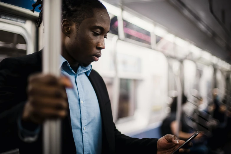 a man on a subway looking at his cell phone, by Carey Morris, trending on unsplash, afro tech, using a magical tablet, avatar image, serious business