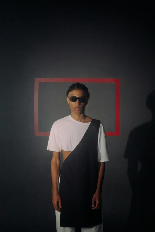 a man standing in front of a black wall, an album cover, inspired by Jean Malouel, digital sunglasses, asian man, performing a music video, in front of white back drop