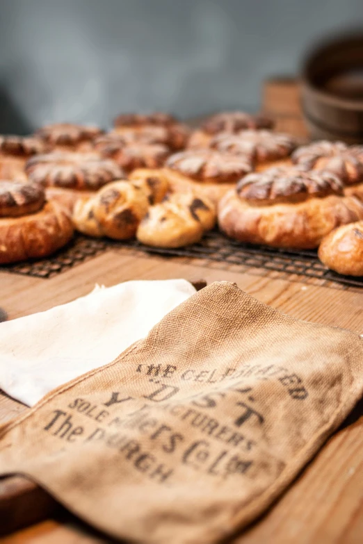 a table topped with lots of pastries on top of a wooden table, pexels contest winner, private press, dirty linen robes, thumbnail, deus ex machina, studio photo