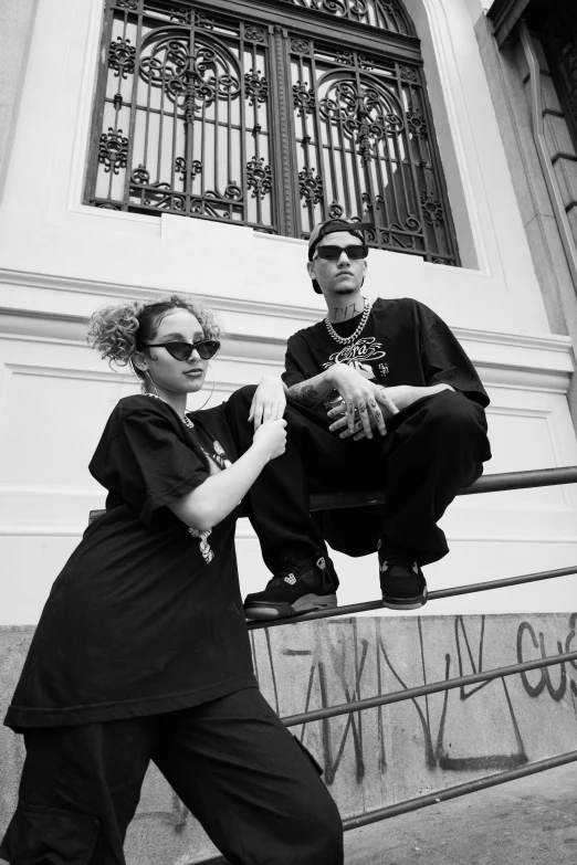 a black and white photo of a man and a woman, by Alexis Grimou, hip hop style, wears the ankh symbol, black oversized clothes, with sunglass