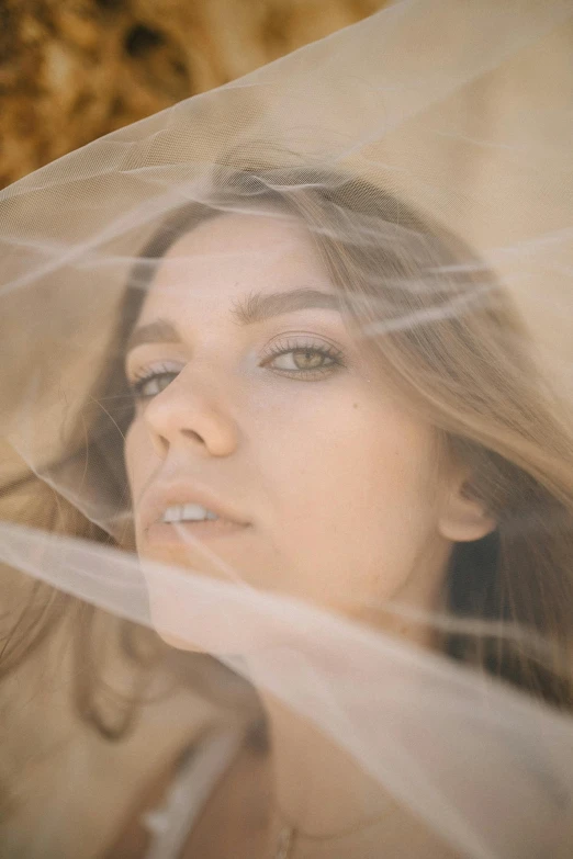 a woman with a veil covering her face, inspired by Elsa Bleda, unsplash contest winner, soft devil queen madison beer, wearing translucent sheet, sydney sweeney, honey - colored eyes