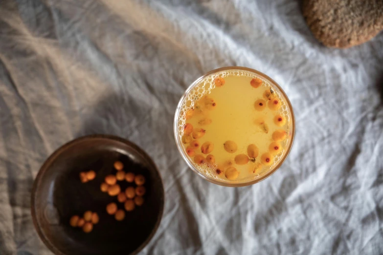 a glass of orange juice next to a bowl of nuts, a portrait, unsplash, renaissance, slime mold, polka dot, birdseye view, bangalore