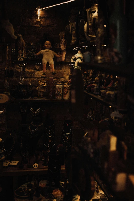 a room filled with lots of different items, a statue, unsplash, assemblage, horror footage, dim lit, toys, voodoo