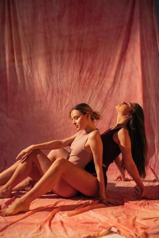 a couple of women sitting on top of a bed, an album cover, by Alice Mason, trending on pexels, arabesque, contemporary dance poses, pink shadows, photoshoot for skincare brand, portrait sophie mudd