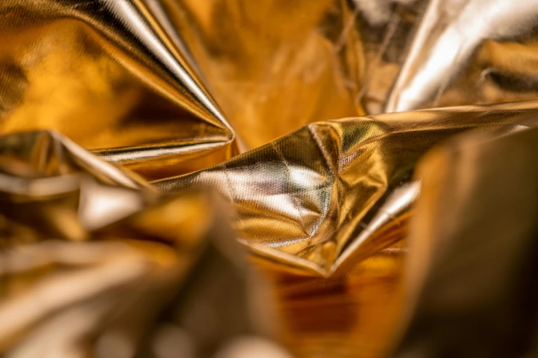 a close up of a shiny gold cloth, an abstract sculpture, inspired by Christo, trending on unsplash, metallic asteroid, frill, palme d'or winner, vinyl material