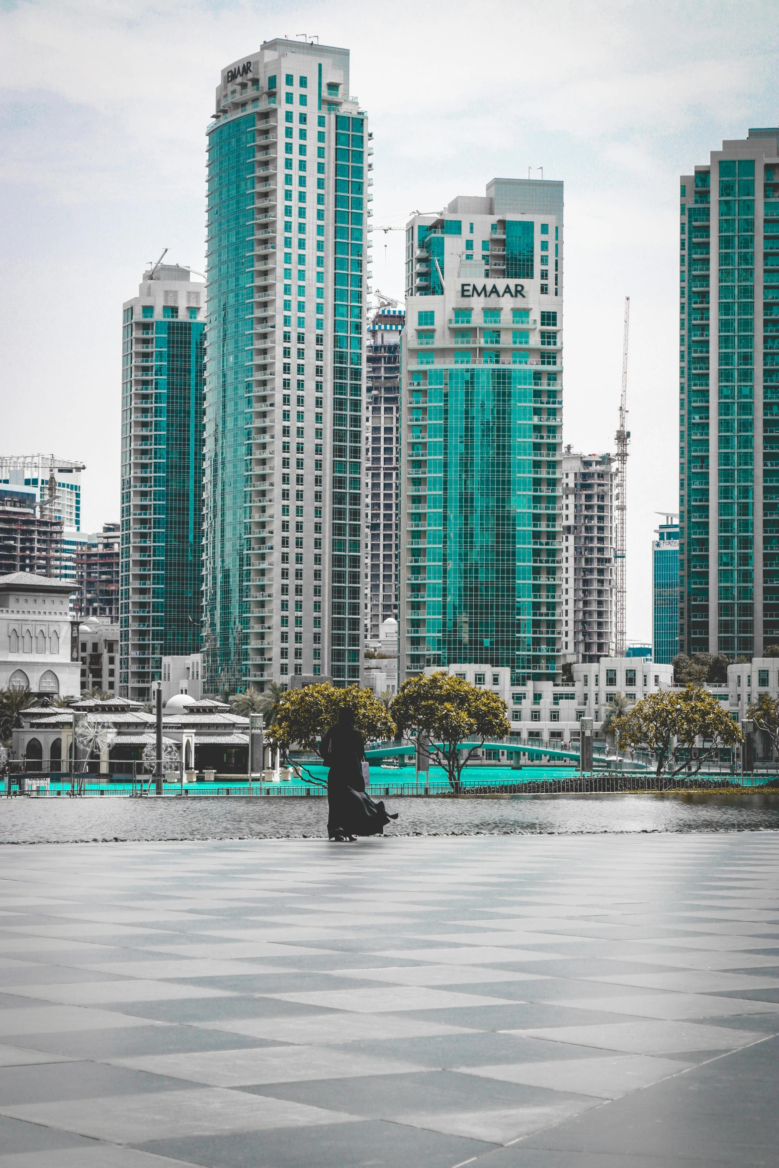 a black and white checkered floor with buildings in the background, a colorized photo, inspired by Erik Pevernagie, pexels contest winner, hurufiyya, standing in a lake, dubai, city buildings on top of trees, jakarta