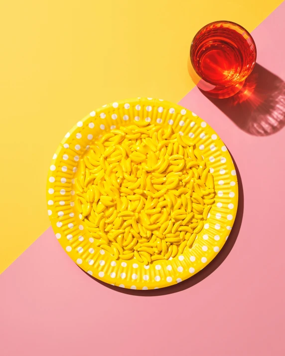 a plate of noodles and a glass of red wine on a pink and yellow background, inspired by Yayou Kusama, trending on unsplash, plasticien, gummy worms, minimalist photorealist, yellow wallpaper