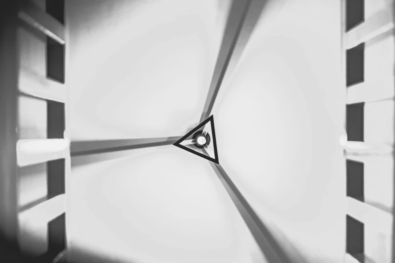 a black and white photo of a clock, by Jan Rustem, unsplash, abstract illusionism, triangle, white ceiling, awarded on cgsociety, one single lamp