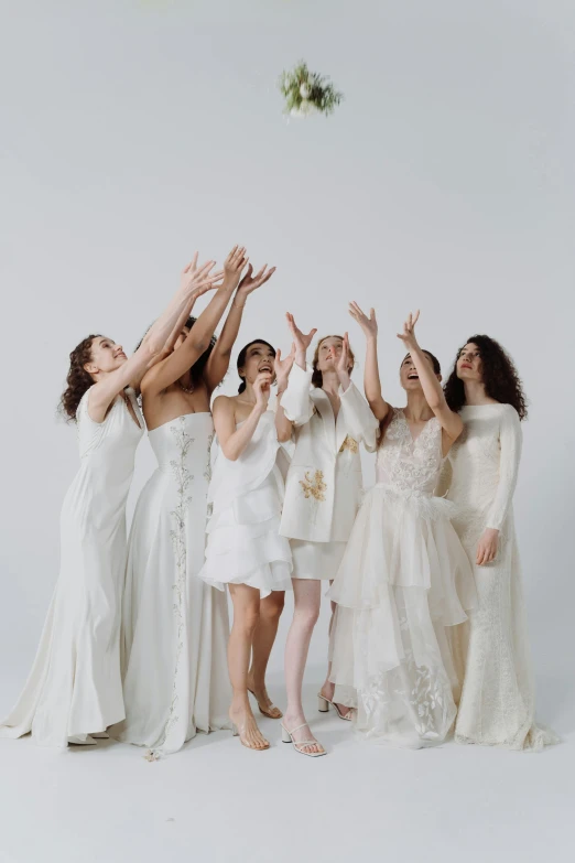 a group of women standing next to each other, by Winona Nelson, trending on pexels, renaissance, white gown, waving and smiling, white studio, lesbians
