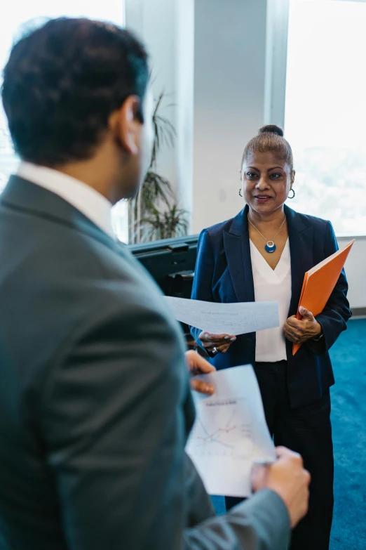 a group of people standing next to each other in a room, woman in business suit, confidential documents, talking, bay area