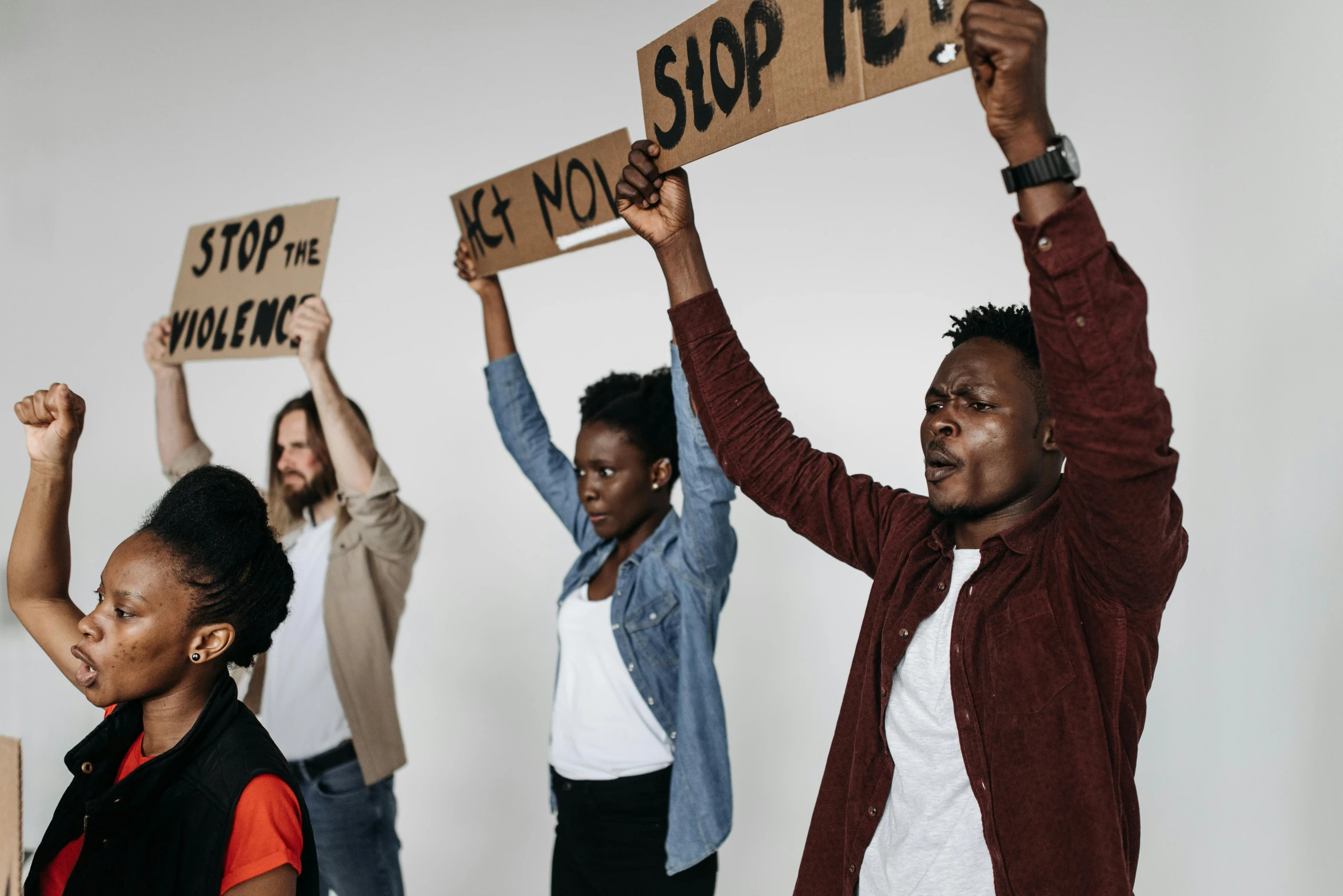 a group of people holding up signs that say stop the violence, by Matija Jama, trending on pexels, avatar image, brown, looking to the right, handheld