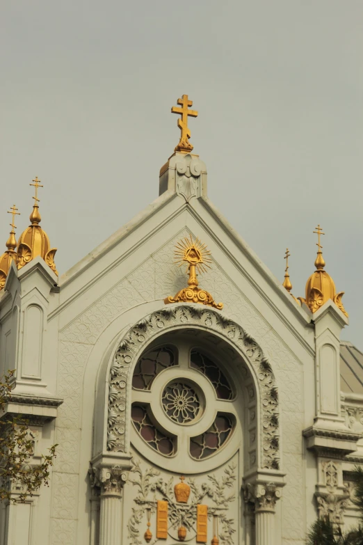 a church with a clock on the front of it, inspired by Christopher Wren, art nouveau, golden ornaments, shanghai, buttresses, “ golden chalice