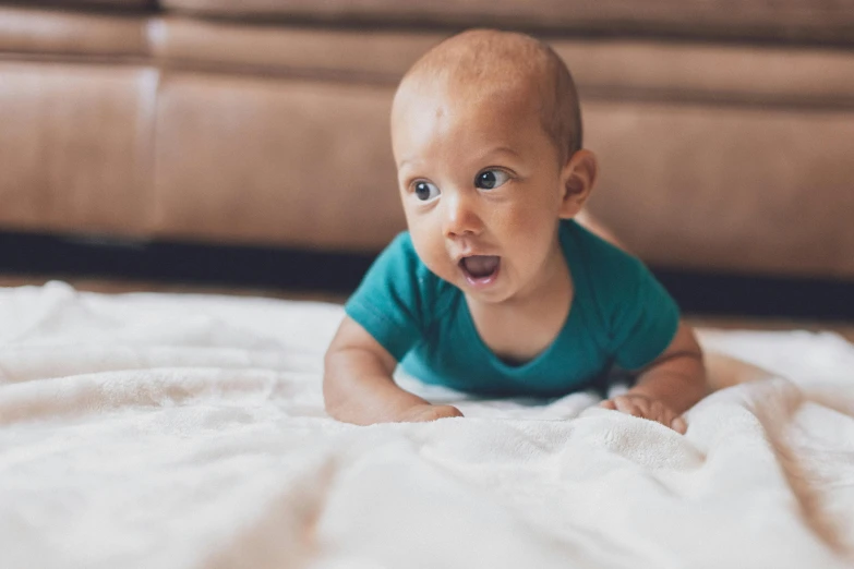 a baby laying on top of a white blanket, pexels contest winner, happening, surprised, cute young man, bumpy, gif