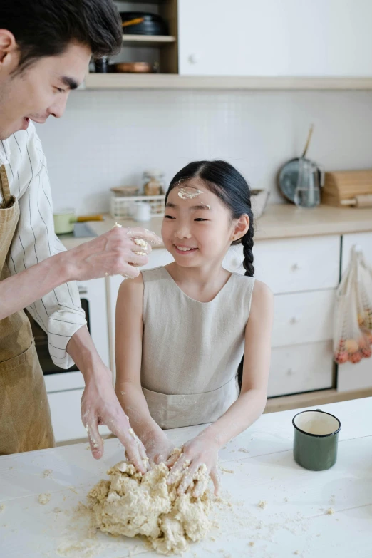 a man standing next to a little girl in a kitchen, by Zeen Chin, pexels contest winner, renaissance, baking cookies, with japanese inspiration, gif, korean woman