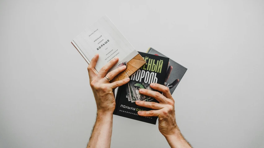 a person holding a book in their hands, by Maksimilijan Vanka, pexels contest winner, hyperrealism, holding a stack of books, kerouac magazine, 000 — википедия, william gibson