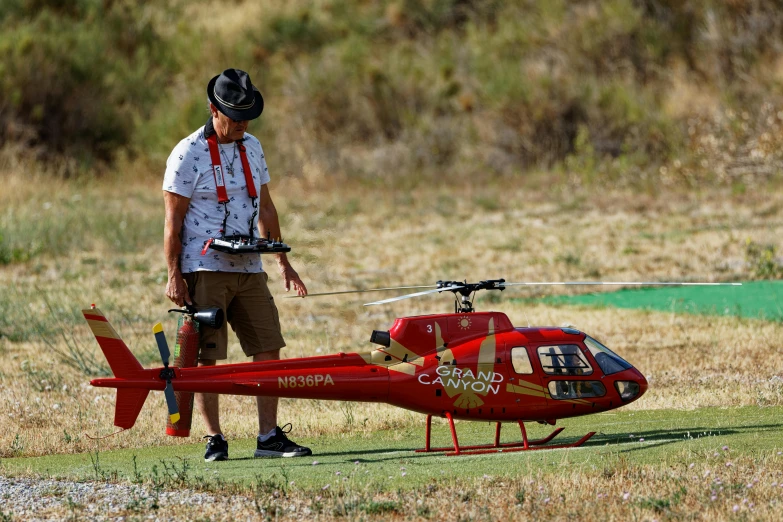 a man standing next to a red helicopter, drone speedways, in spain, avatar image