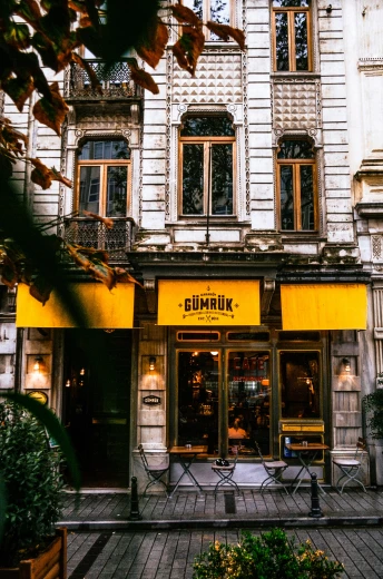 a building with a yellow awning in front of it, a picture, inspired by Gillis Rombouts, pexels contest winner, art nouveau, gourmet restaurant, istanbul, gunpla, climax
